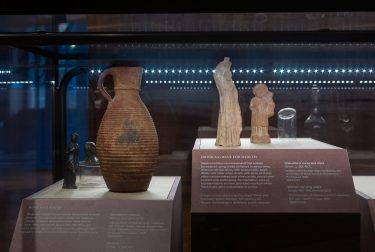 Ceramic jugs in a glass case in an exhibition